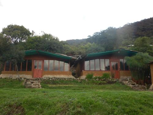 a house that is sitting in the grass at Llactapata Lodge overlooking Machu Picchu - camping - restaurant in Salcantay