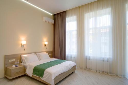 ein Schlafzimmer mit einem Bett und einem großen Fenster in der Unterkunft Summit Apart Hotel in Kiew
