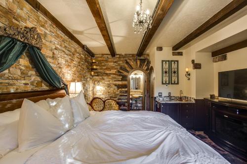 a bedroom with a bed and a brick wall at Storybook Riverside Inn in Leavenworth