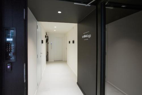 ヘントにあるSnooz Ap Holiday & Business Flatsの白壁と黒い扉の廊下