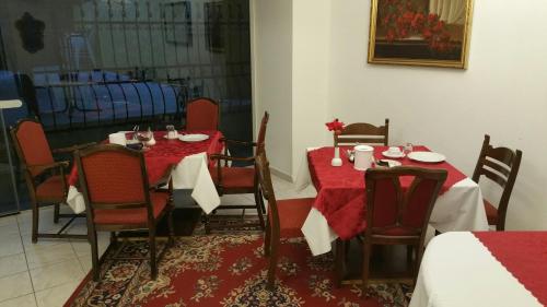 a dining room with two tables and chairs with red table cloth at Appartement Hotel Marien-Hof in Vienna