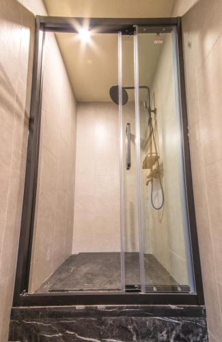 a shower with a glass door in a bathroom at Hangzhou Van Wind Inn in Hangzhou