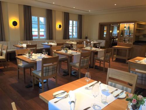 a restaurant with wooden tables and chairs in a room at Flair Hotel Schwanen in Bad Bellingen