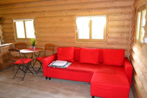 a living room with a red couch and a table at Camping Szczecinek Domy Wypoczynkowe in Szczecinek