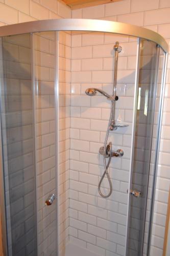 a shower with a glass door in a bathroom at Camping Szczecinek Domy Wypoczynkowe in Szczecinek