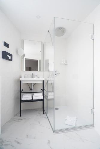 a bathroom with a glass shower and a sink at Doisy Etoile - Orso Hotels in Paris