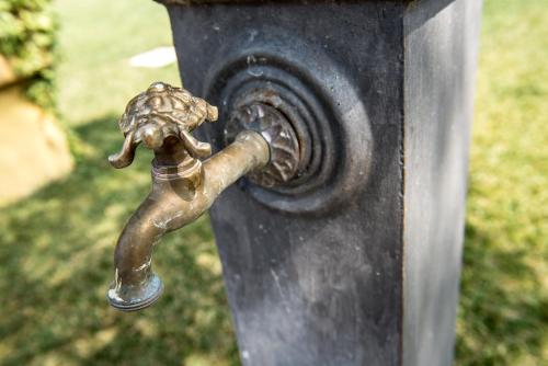 a bronze faucet on a black post at Country Resort Le Due Ruote in Alberese