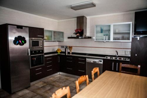 Casa Rural Tolareta في Arantza: مطبخ مع طاولة وثلاجة حديد قابلة للصدأ