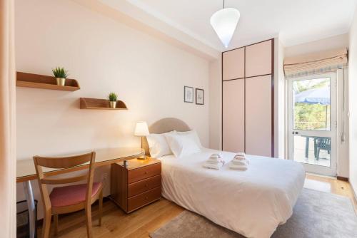 ブラガにあるRH Charming Apartment São Victorのベッドルーム1室(ベッド1台、デスク、椅子付)