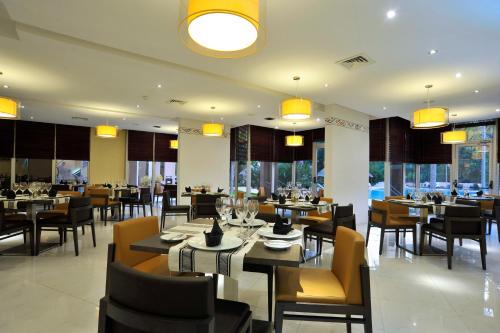a dining room with tables and chairs in a restaurant at Sopatel Silmandé in Ouagadougou
