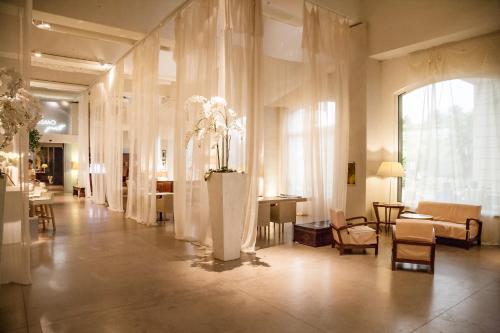 a lobby with a room with white curtains and flowers at Cosmo Hotel Palace in Cinisello Balsamo
