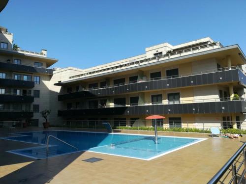 un edificio con piscina frente a un edificio en Apartamento Playa Silgar, en Sanxenxo