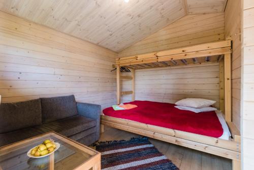 ein Bett und ein Sofa in einem Holzzimmer in der Unterkunft Reta Puhkemajad in Haapsalu