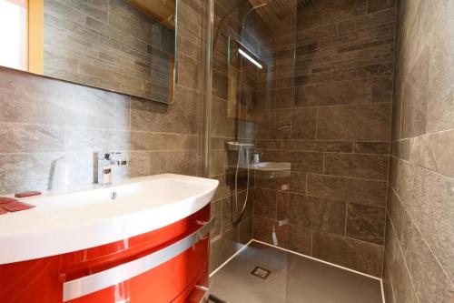 a bathroom with a sink and a shower at L'Auberge au Bord du Lac in Gérardmer