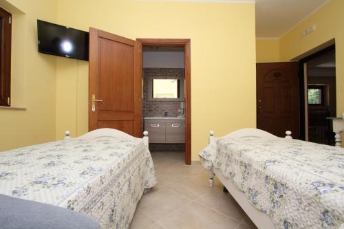 Piedimonte San GermanoにあるAzienda Agrituristica La Tenuta del Falcoのベッドルーム1室(ベッド2台、壁掛けテレビ付)