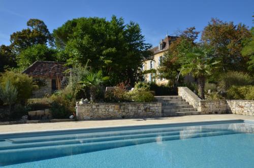une maison avec une piscine en face d'une maison dans l'établissement Château Le Tour - Chambres d'Hôtes, à Faux