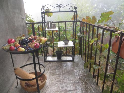a bowl of fruit on a stand on a balcony at Guest House Kamea in Sighnaghi