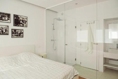 a white bedroom with a shower and a bed at The Flat Gent in Ghent
