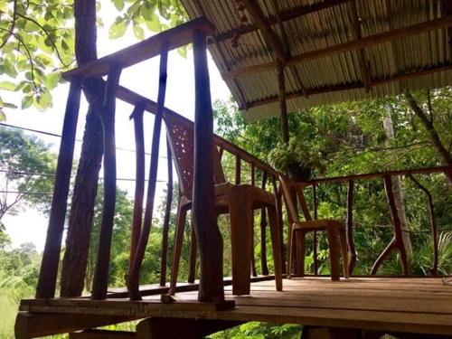 a wooden deck with a chair on a porch at Angry Birds Tree house in Habarana