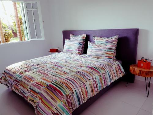 a bed with a colorful comforter in a bedroom at Oxygène in Marrakech