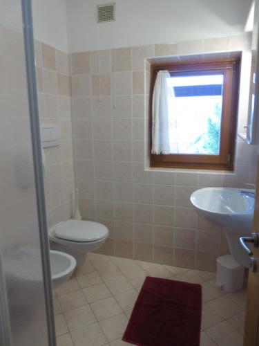 łazienka z toaletą i umywalką w obiekcie Agritur Maso Pomarolli w mieście Giovo