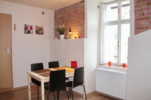 a dining room table with chairs and a brick wall at Comfortable apartments under the St. Barbara´s Cathedral in Kutná Hora