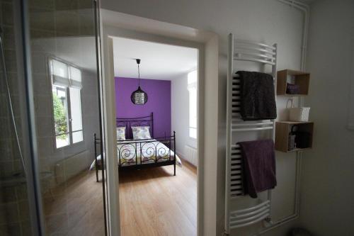 Habitación con dormitorio con cama y puerta de cristal. en La Petite Madame, en Moret-sur-Loing