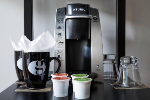 a coffee maker and some cups on a counter at Hotel Grinnell, Ascend Hotel Collection in Grinnell