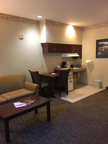 a living room with a couch and a table and a kitchen at Hawthorn Suites by Wyndham Rancho Cordova/Folsom in Rancho Cordova