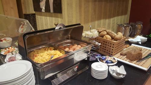 - un buffet avec des œufs et d'autres aliments sur une table dans l'établissement Hotel Brinckmansdorf, à Rostock