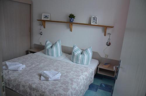 - une chambre avec un lit doté d'oreillers bleus et blancs dans l'établissement Haus Vineta, à Thiessow