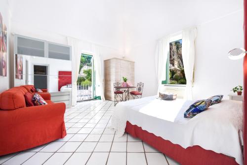 a bedroom with a large bed and a red couch at Cartiera Apartment with Pool by AMALFIVACATION in Amalfi