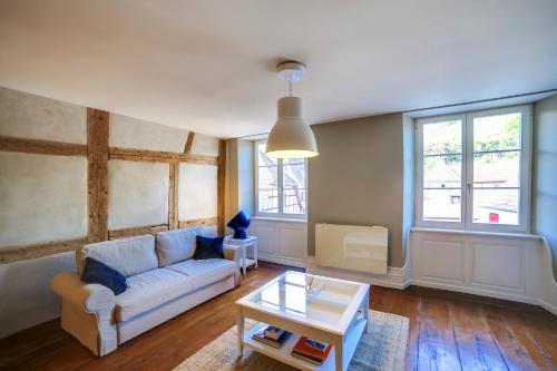 ein Wohnzimmer mit Couch und Tisch in der Unterkunft Andlau, Cour de l'Abbaye in Andlau