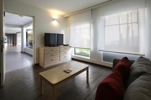 a living room with a couch and a tv at Casa Andina Premium Piura in Piura