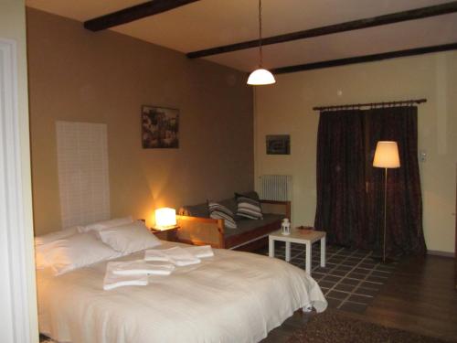 a bedroom with a large white bed and a couch at Maison Christiana's in Kalavrita