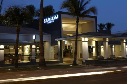 a store with palm trees in front of it at night at Casa Andina Premium Piura in Piura