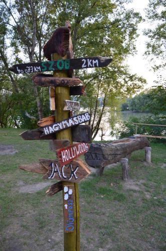 a wooden sign with many signs on it at Őzgida Nyaralóház in Zebegény