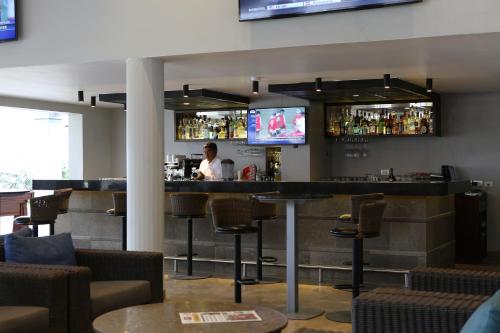 a man standing at a bar in a restaurant at Casa Andina Premium Piura in Piura