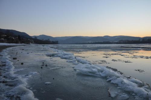 an icy river with snow on the shore at Őzgida Nyaralóház in Zebegény