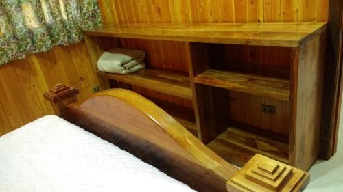 a room with a bed in a wooden room at Cabañas Tornagaleones Villarrica in Villarrica