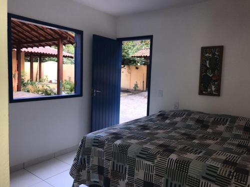 a bedroom with a bed and a large window at Recanto das Geraes in Arraial d'Ajuda