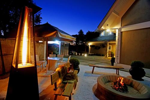 a patio with a fire pit and a table and bench at Vila de Charme Suítes in Campos do Jordão