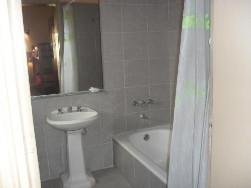 a bathroom with a sink and a toilet and a bath tub at Hotel De La Rue in Buenos Aires