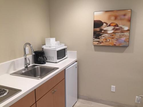 a kitchen with a sink and a microwave at Diamond Head Inn in San Diego