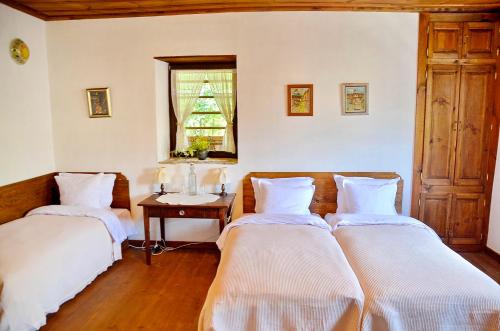 コヴァチェヴィカにあるKalinia Guesthouse B&Bのベッド2台、テーブル、窓が備わる客室です。