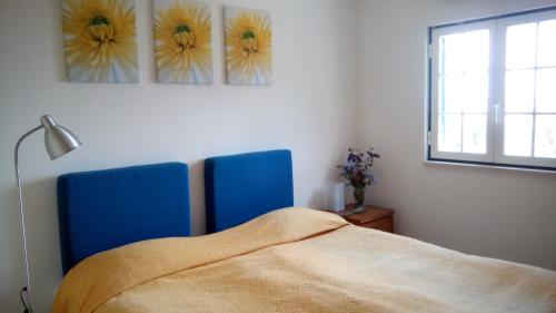 een slaapkamer met een bed en twee blauwe stoelen bij Logra-Sol in Figueira da Foz