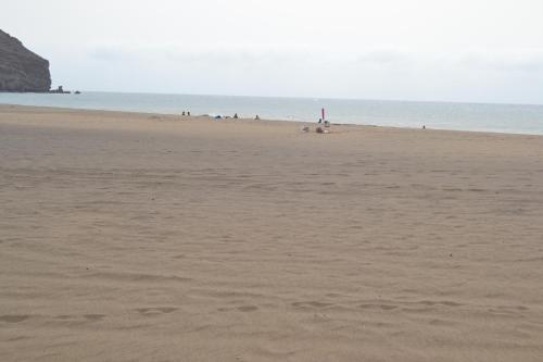 a sandy beach with people in the water at Casa Mararía in Gran Tarajal