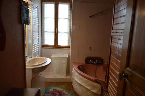 a bathroom with a bath tub and a sink at Le Tilleul in Anglars