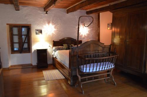 a bedroom with a wooden bed in a room at Le Figuier in Anglars