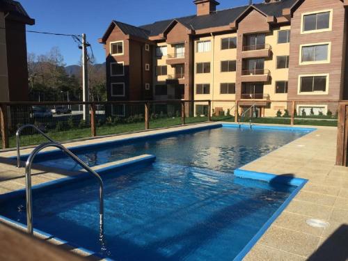 una piscina frente a un complejo de apartamentos en Departamento Pucon, en Pucón